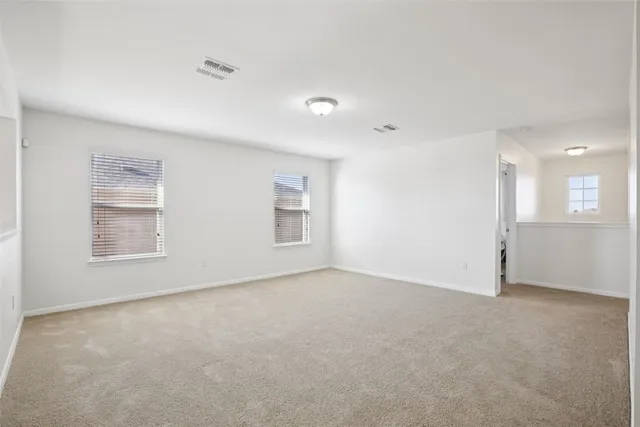 an empty room with white walls and windows