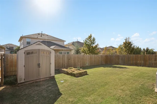 a view of a chair and table in backyard of the house