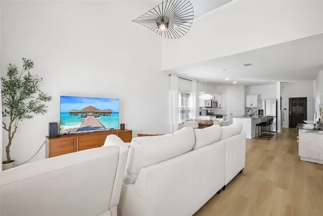 a living room with furniture a chandelier and a floor to ceiling window
