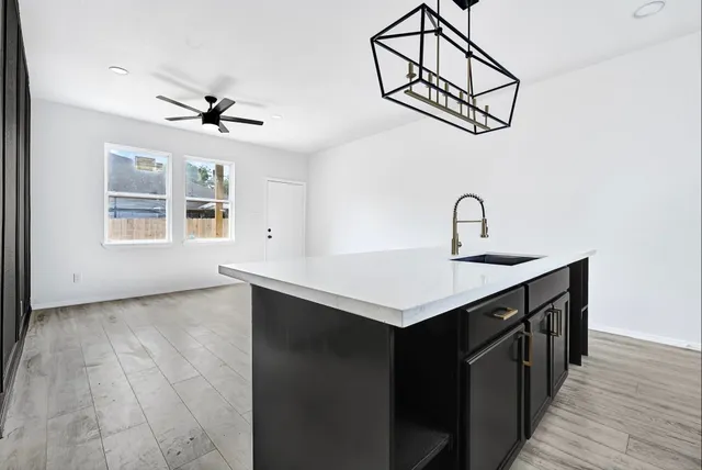 a kitchen with a sink cabinets and wooden floor