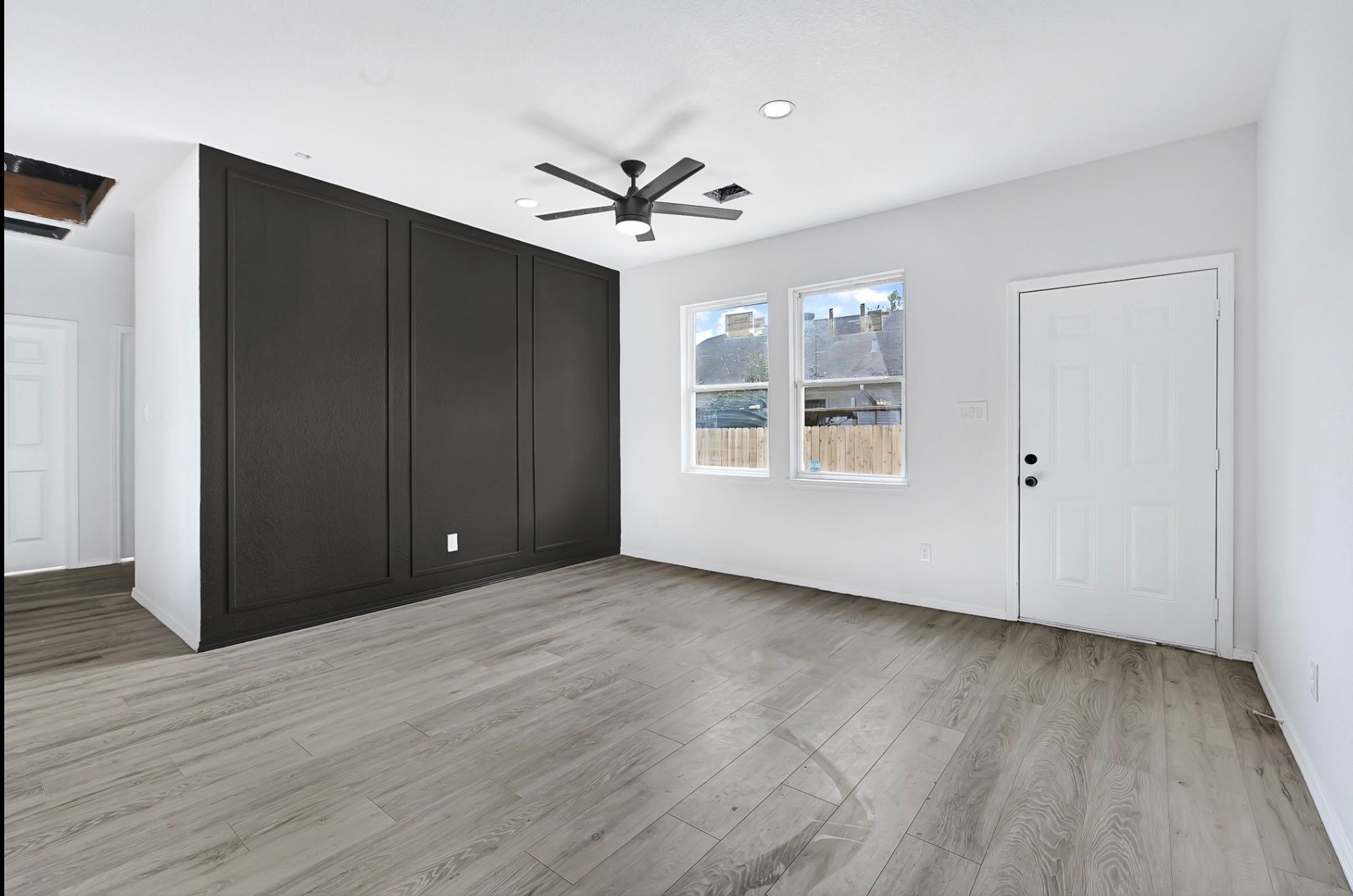 7939 Goode Street Houston, TX 77012 - Photo 8 of 14 a view of an empty room with wooden floor and a ceiling fan