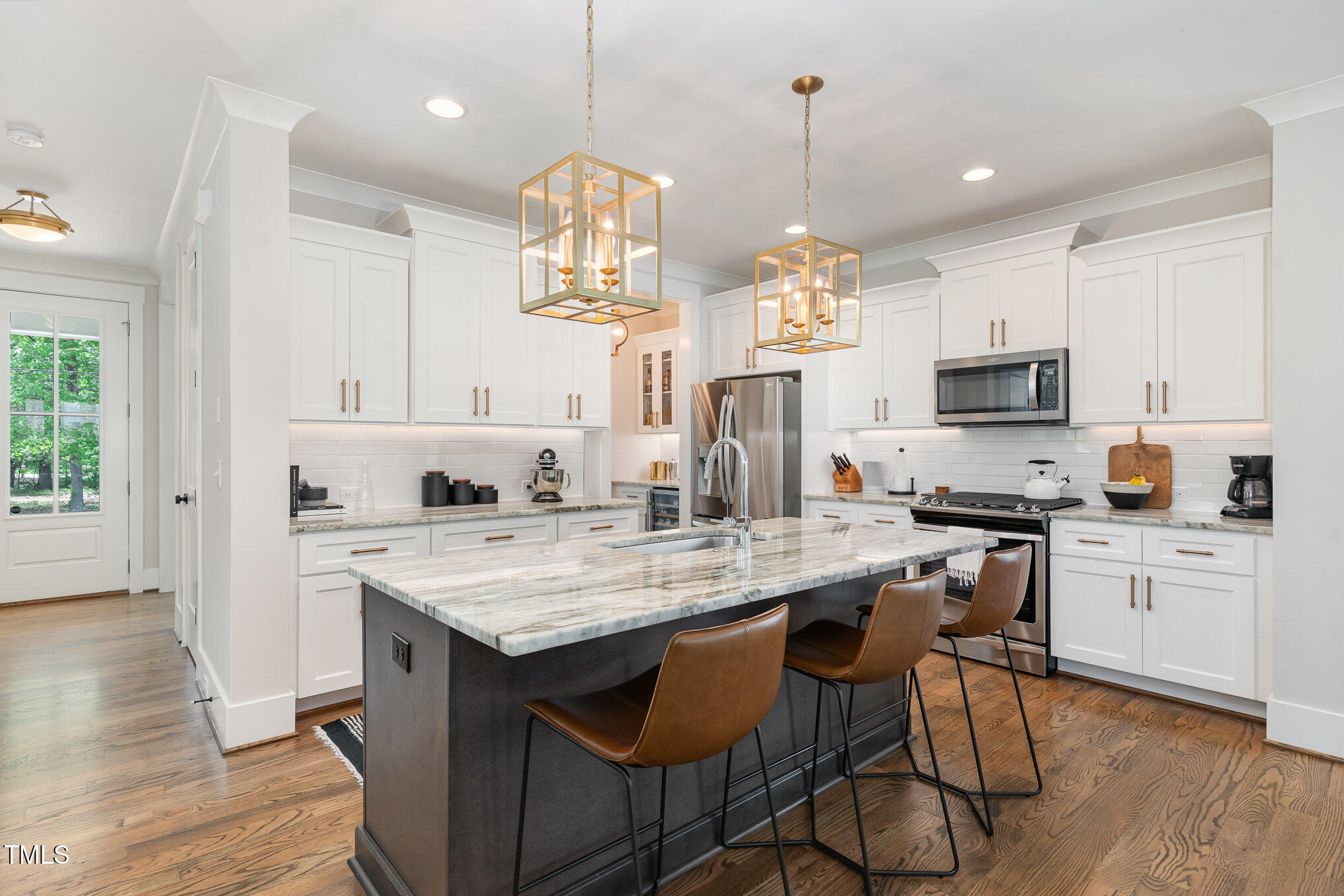 1422 Banbury Road Raleigh, NC 27607 - Photo 10 of 48 a kitchen with stainless steel appliances granite countertop a stove top oven a refrigerator a sink and white cabinets with wooden floor