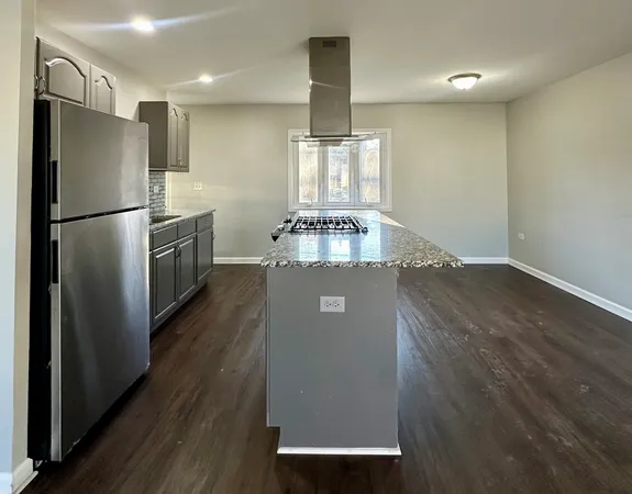 a view of a refrigerator in kitchen and wooden floor