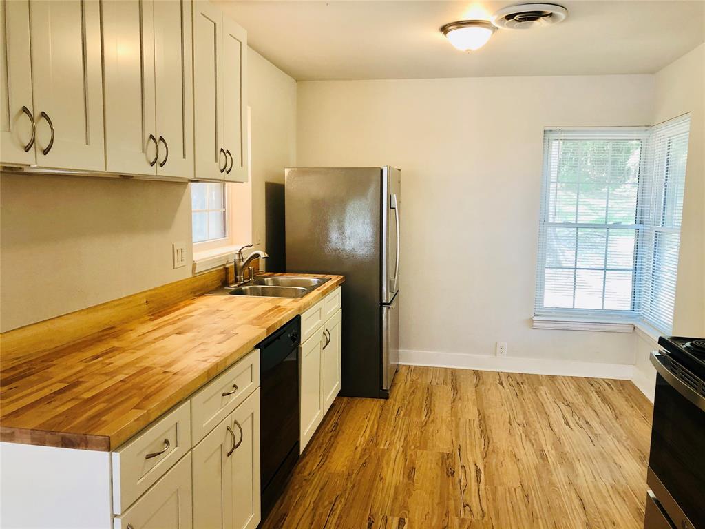 716 Kessler Boulevard Sherman, TX 75092 - Photo 9 of 27 Kitchen featuring wood counters, wood finished floors, dishwasher, stove, and freestanding refrigerator