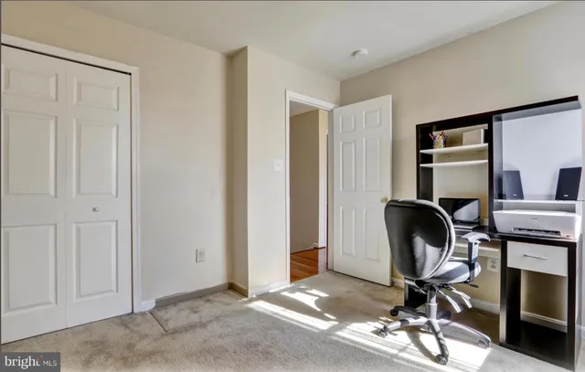a view of a workspace with furniture and a window