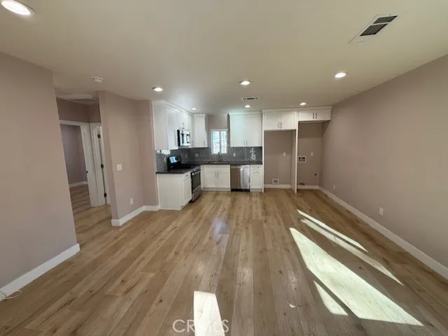 a view of a kitchen with cabinets and wooden floor