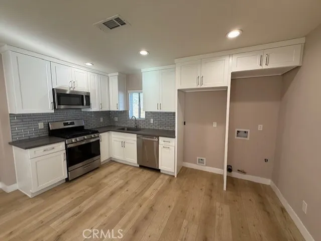a kitchen with granite countertop a refrigerator and a stove top oven