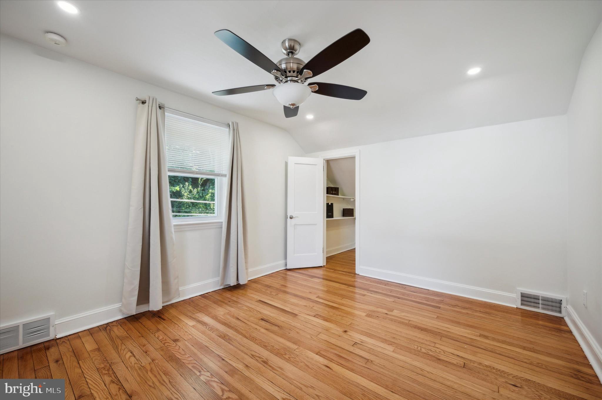 907 Powder Mill Lane Wynnewood, PA 19096 - Photo 20 of 31 a view of an empty room with wooden floor and a ceiling fan