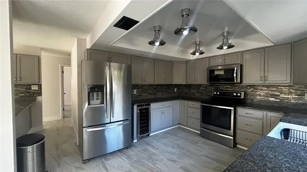 a kitchen with stainless steel appliances granite countertop a refrigerator and a stove top oven
