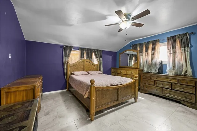 a bed room with a bed and a ceiling fan