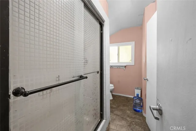 a bathroom with a granite countertop shower and a toilet