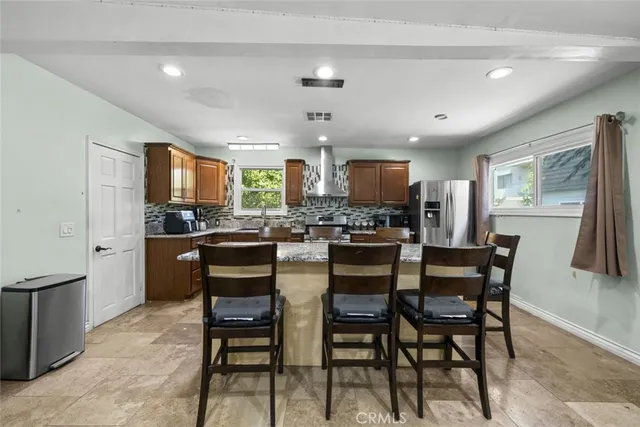 a kitchen with kitchen island granite countertop wooden cabinets and stainless steel appliances