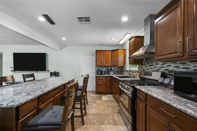 a kitchen with stainless steel appliances granite countertop a stove a sink and a microwave