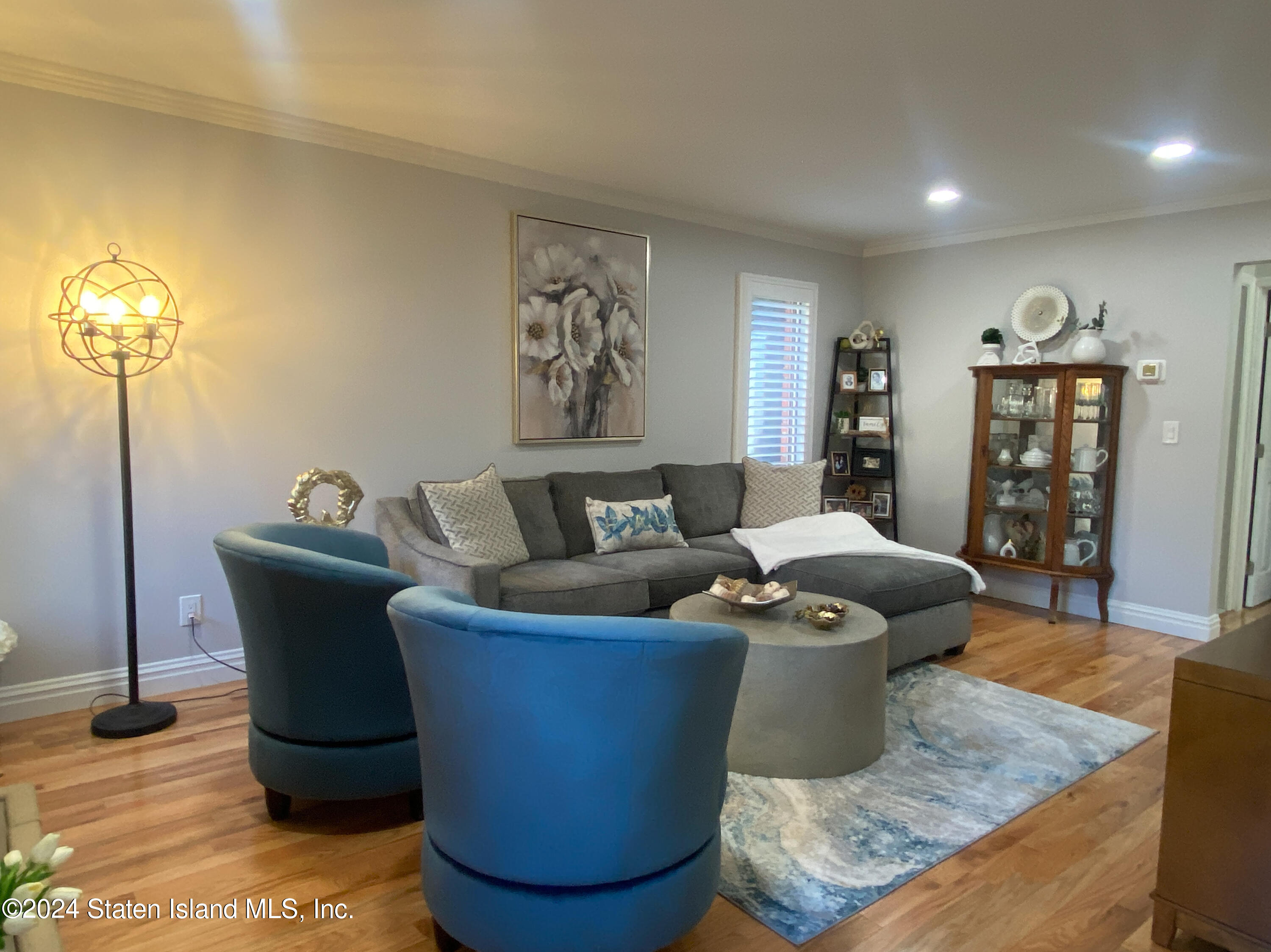1440 Forest Hill Road, Unit 2 Staten Island, NY 10314 - Photo 11 of 32 a living room with furniture a lamp and a window