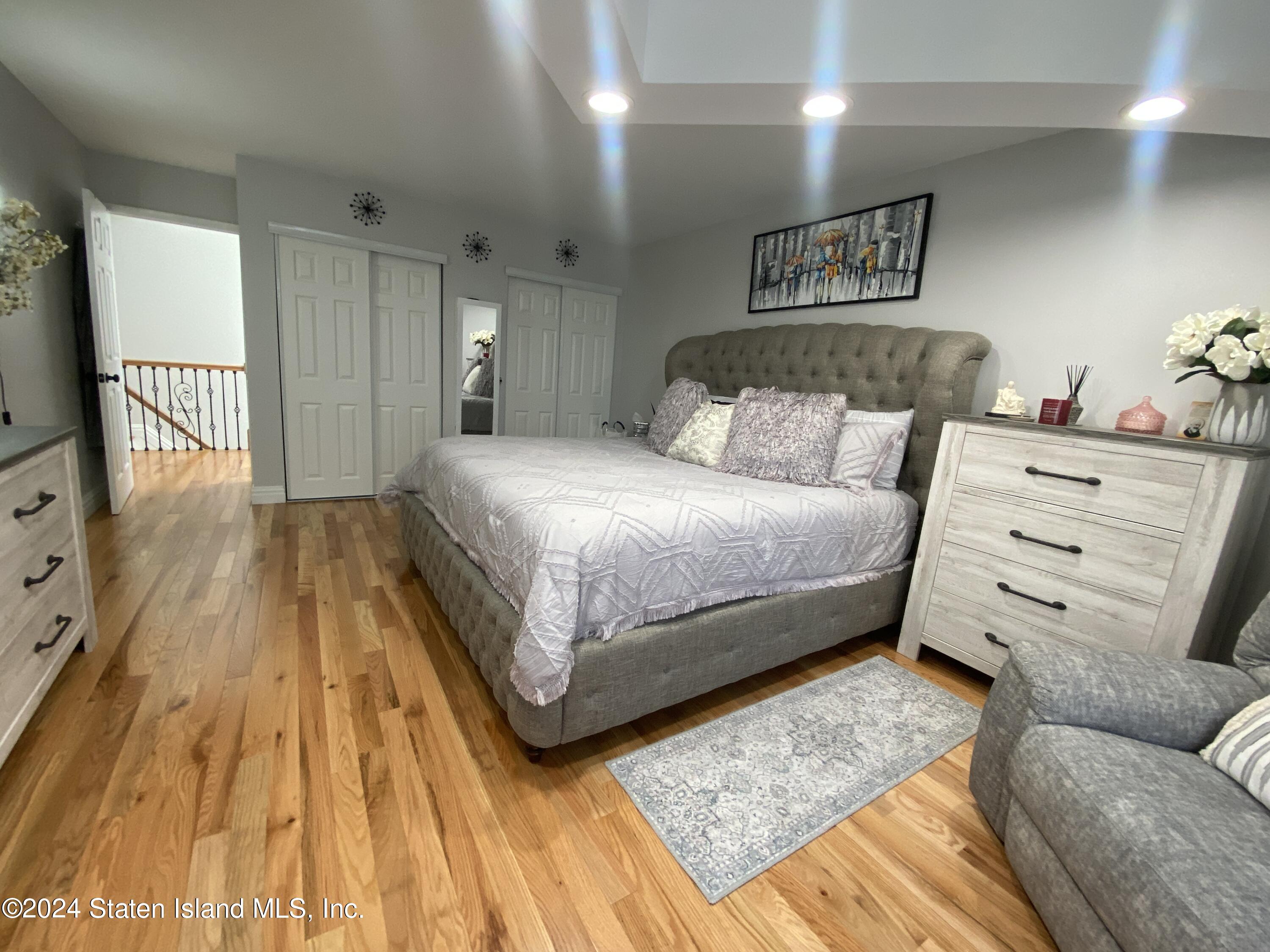 1440 Forest Hill Road, Unit 2 Staten Island, NY 10314 - Photo 16 of 32 a spacious bedroom with a bed and a couch