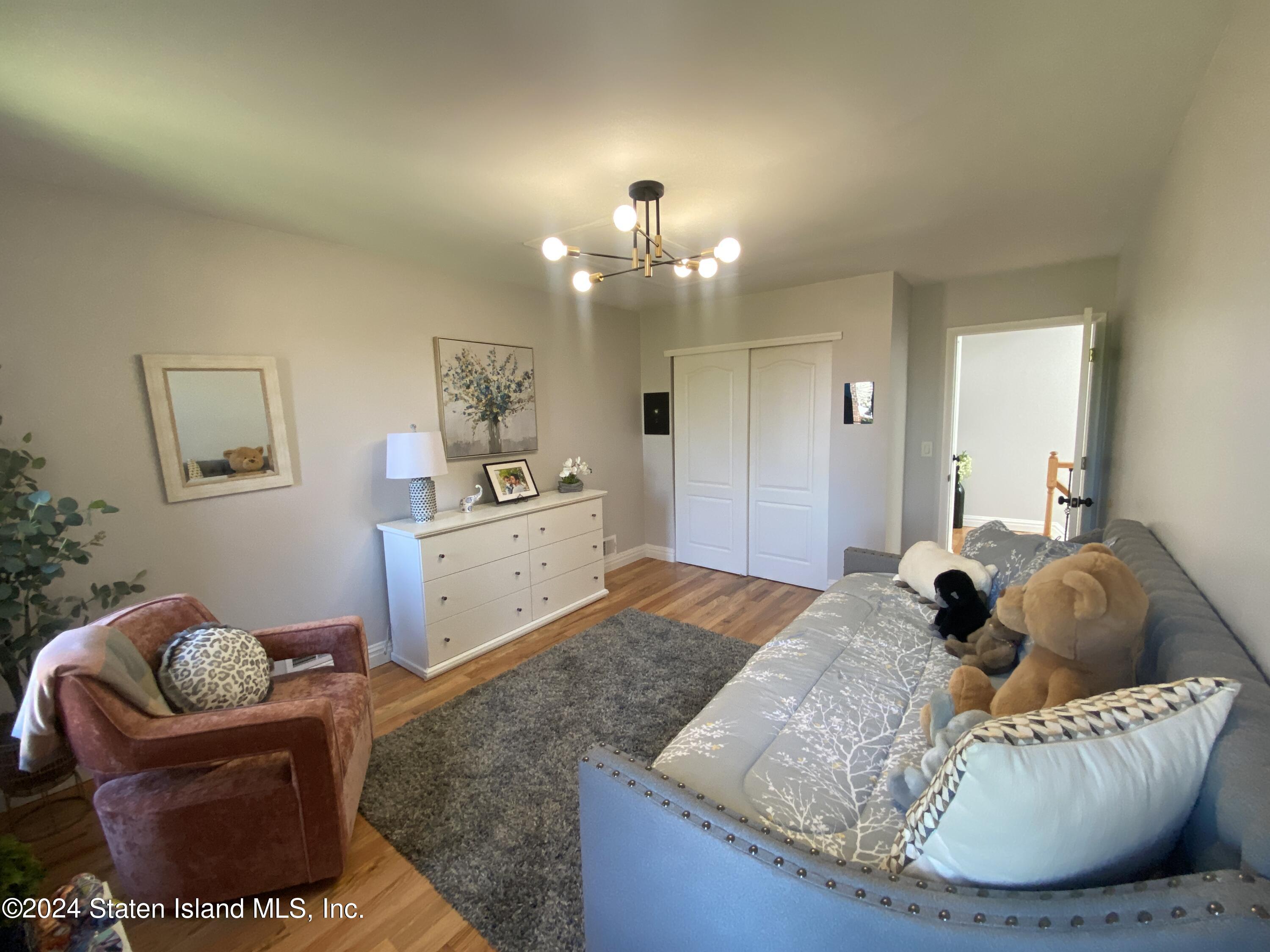 1440 Forest Hill Road, Unit 2 Staten Island, NY 10314 - Photo 19 of 32 a living room with furniture and a chandelier