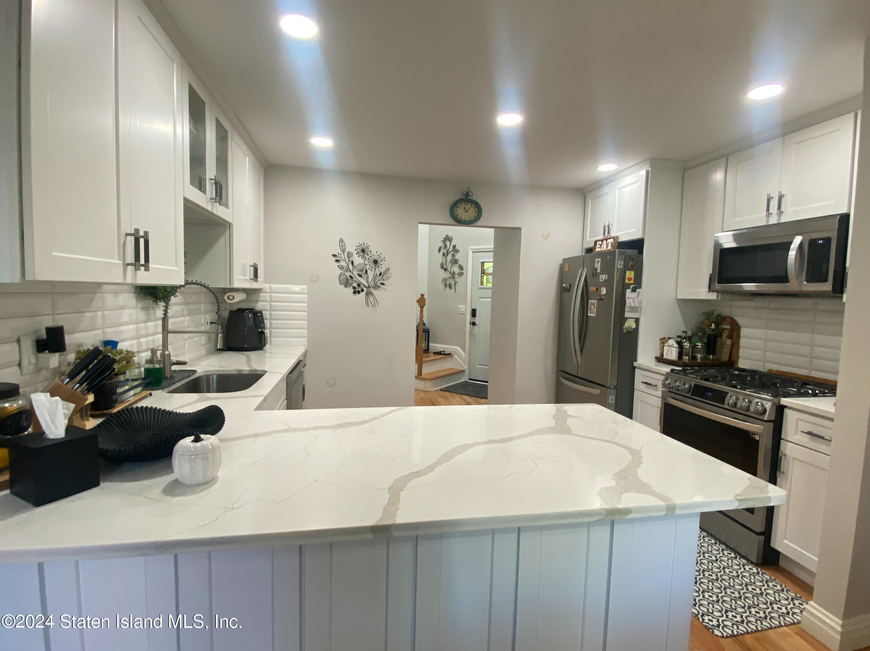 1440 Forest Hill Road, Unit 2 Staten Island, NY 10314 - Photo 6 of 32 a kitchen with stainless steel appliances kitchen island granite countertop a refrigerator and a stove top oven