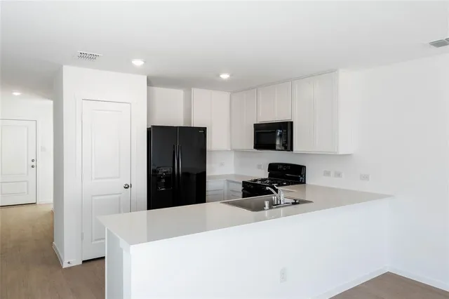 a kitchen with stainless steel appliances a refrigerator stove microwave and cabinets