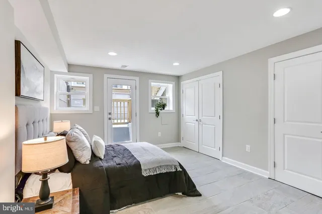 a spacious bedroom with a bed and wooden floor
