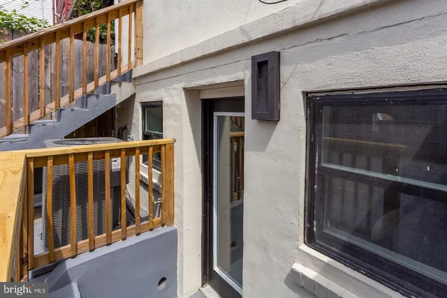 a view of a house with a wooden deck and furniture
