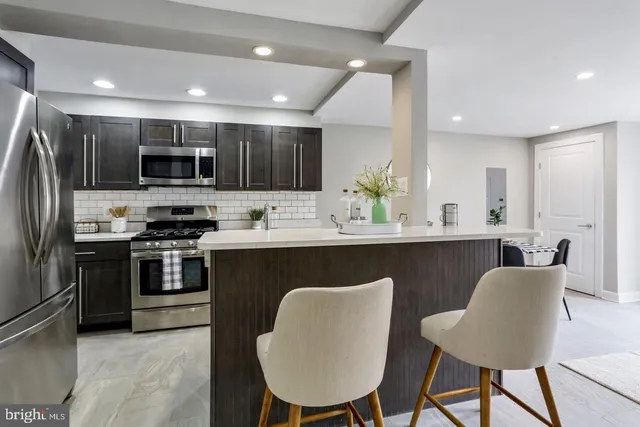 a kitchen with stainless steel appliances granite countertop a stove a sink a microwave a refrigerator and a refrigerator