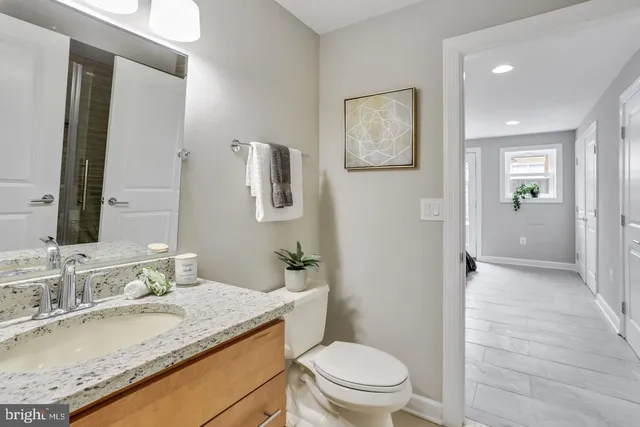 a bathroom with a granite countertop sink toilet and shower