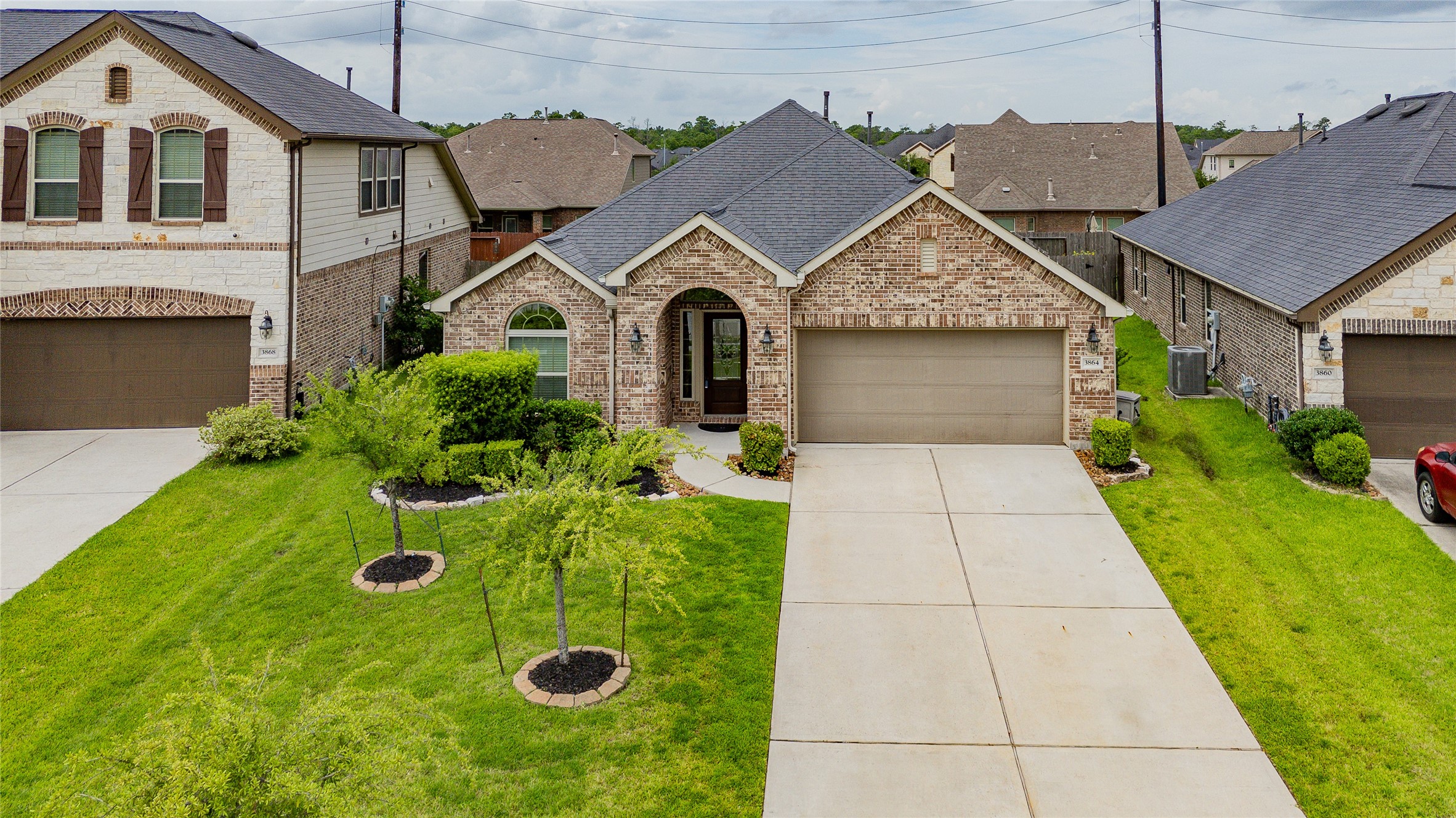 3864 Oakmist Bend Lane Spring, TX 77386 - Photo 2 of 38 a front view of a house with a yard and garage
