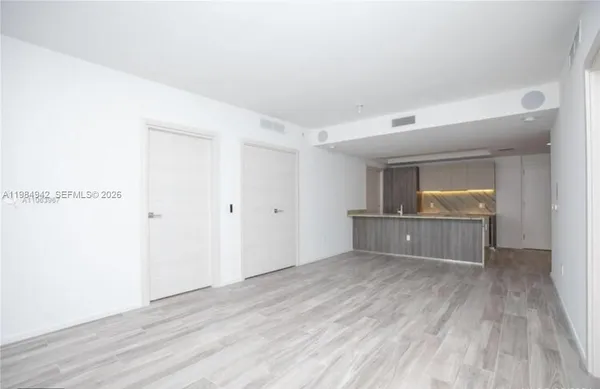 a view of empty room with wooden floor