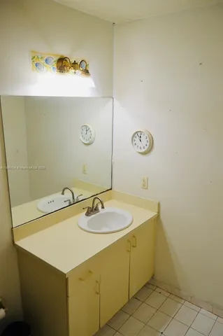 a view of an empty room with chandelier fan