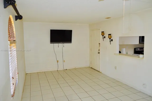 a view of a livingroom with wooden floor and a flat screen tv