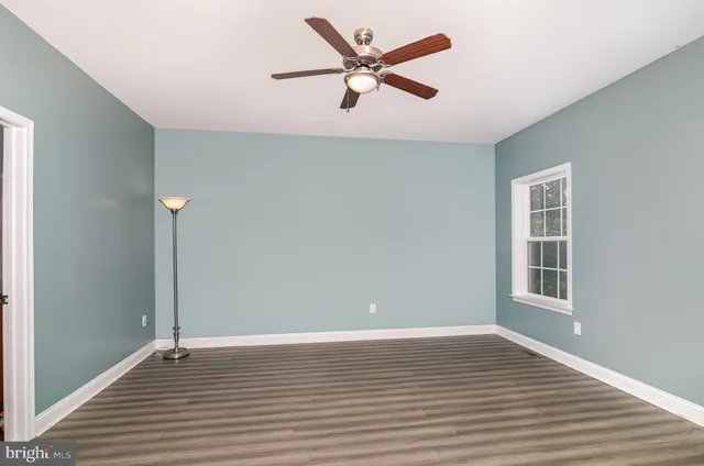 a view of a livingroom with wooden floor and a ceiling fan