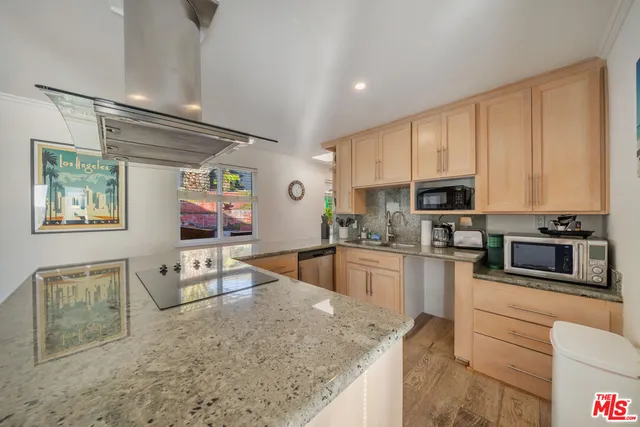 a kitchen with granite countertop a sink stove and cabinets