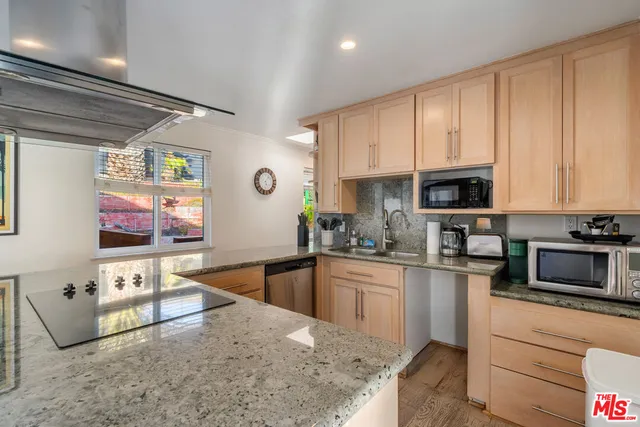 a kitchen with a stove sink and a granite counter top