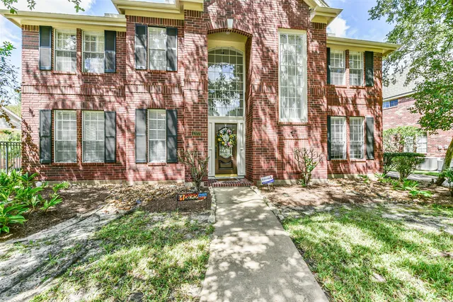 a backyard of a brick building with large windows