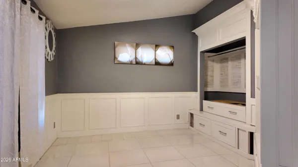 a view of an empty room with cabinet and mirror