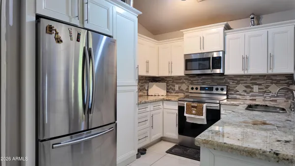 a kitchen with cabinets stainless steel appliances and a counter space