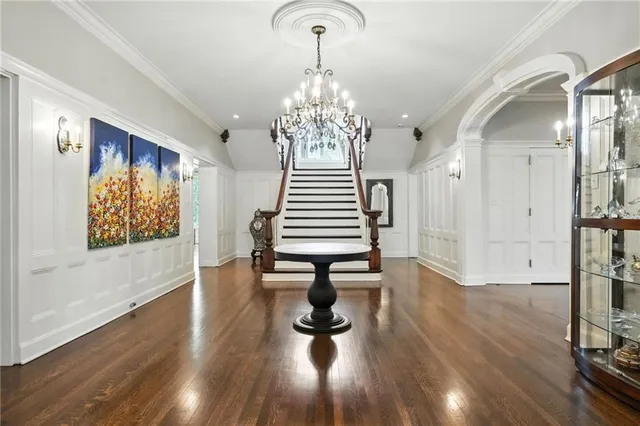 a view of a hallway with wooden floor windows and a chandelier