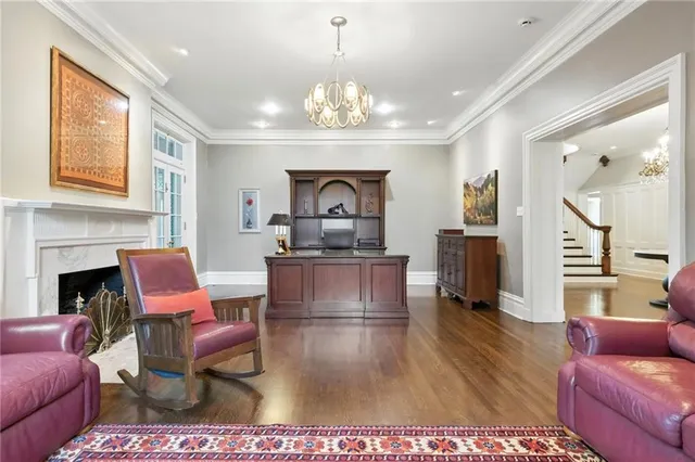 a living room with furniture a fireplace and a chandelier
