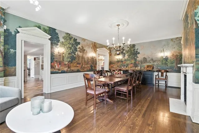a dining room with furniture a chandelier and wooden floor