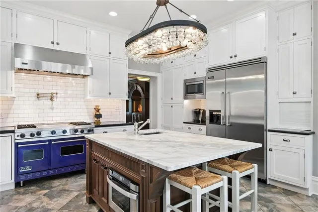 a kitchen with stainless steel appliances granite countertop a stove a sink dishwasher and a refrigerator