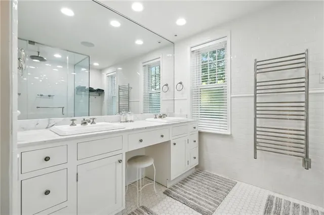 a bathroom with a double vanity sink a mirror and a bathtub