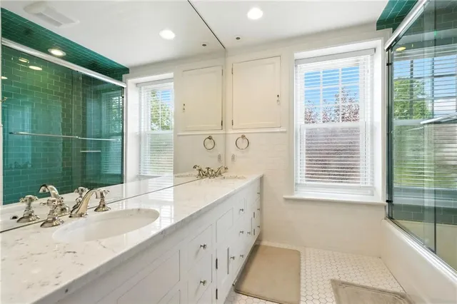 a bathroom with a tub sink and mirror