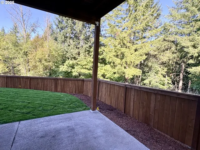 a view of backyard with wooden fence