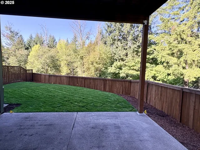 a view of backyard with wooden fence