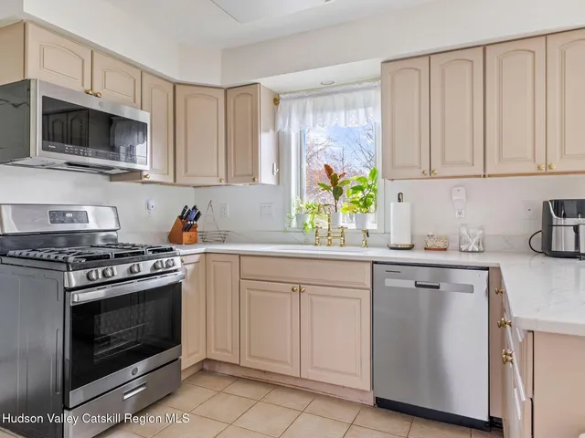 a kitchen with white cabinets and appliances