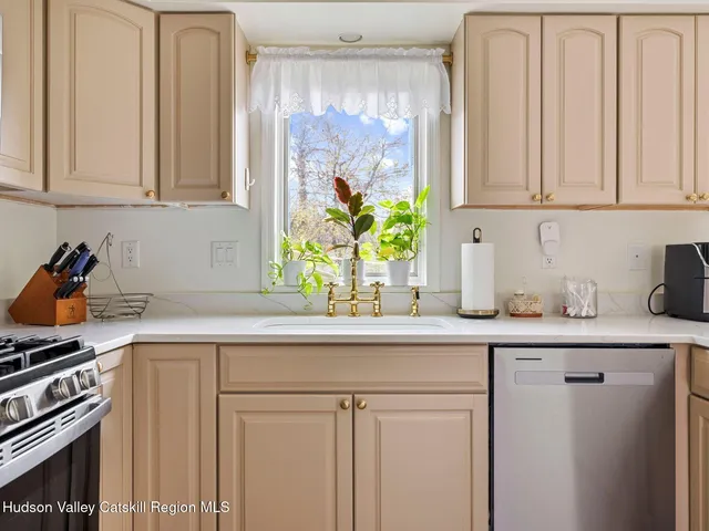 a kitchen with stainless steel appliances white cabinets and a window