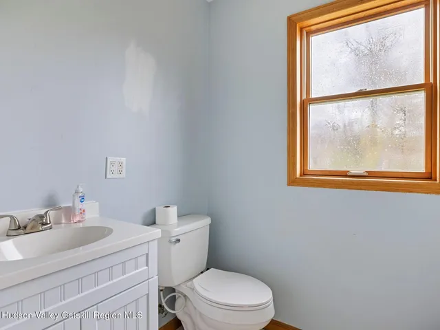 a bathroom with a sink vanity mirror and toilet