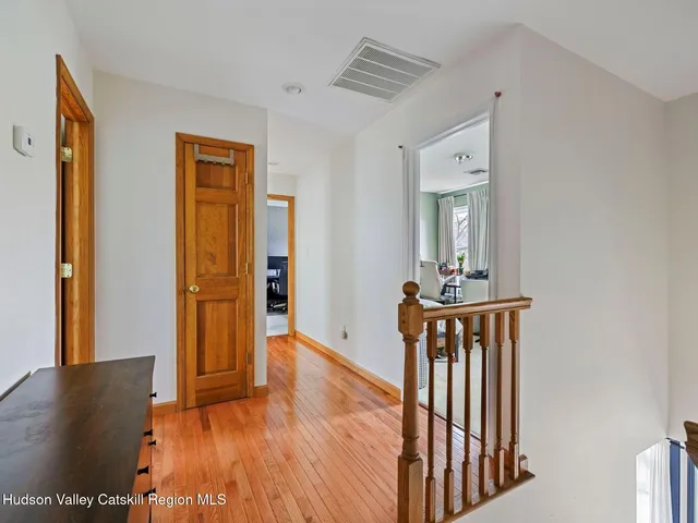 a view of a hallway with wooden floor and furniture