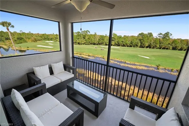 a living room with stainless steel appliances furniture and a kitchen view