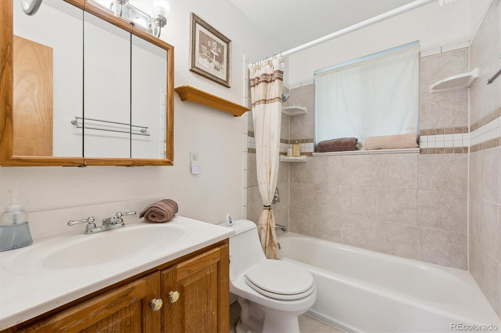 200 Perry Street Denver, CO 80219 - Photo 16 of 24 a bathroom with a sink a toilet and shower